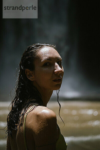 Woman traveler at the waterfall portrait close-up