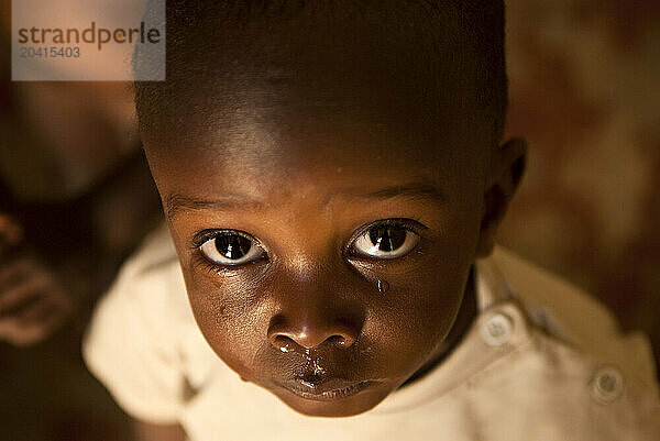 A young boy awaits a bath at the Cornel Ngaleku Children's Centre in Tanzania  Africa.