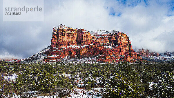 Snowy Courthouse Butte looms over green pines  Sedona