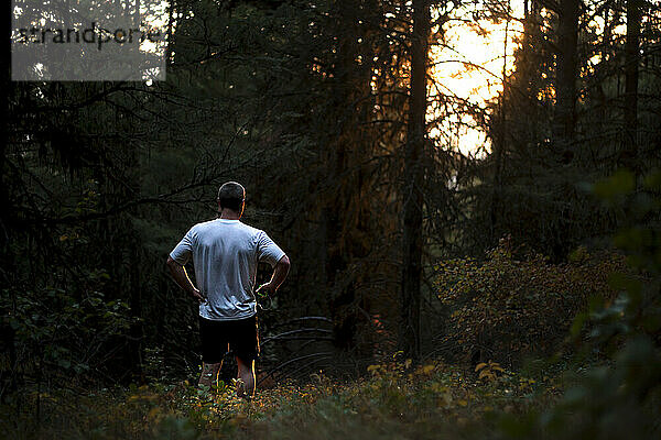 Trail runner standing in woods in Rattlesnake Mountains near Missoula  Montana  USA