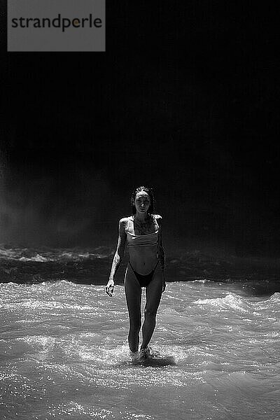 Woman traveler at the waterfall Nung Nung. Black and white. Bali