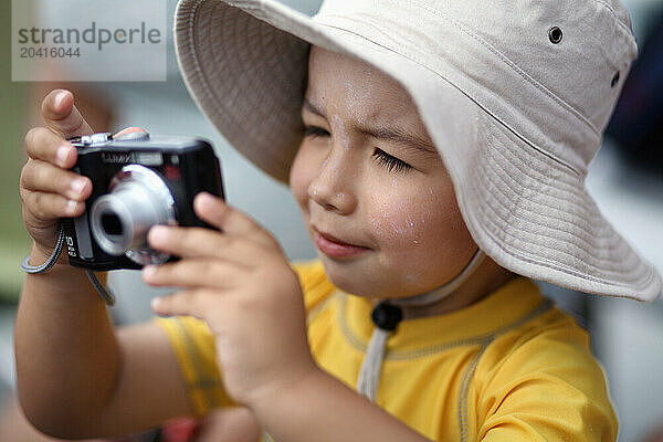 A boy plays with a digital camera.