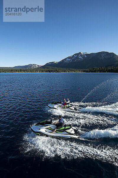 Three friends ride WaveRunners on Lake Tahoe  California.