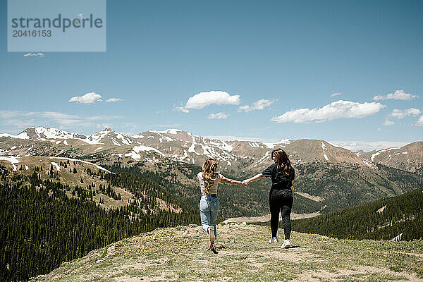 Best friends holding hands in the mountians