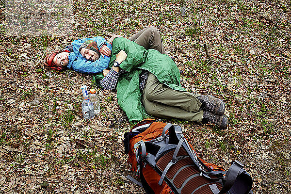 Two hikers cuddle on a misty day.