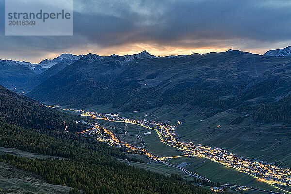 Alpine village of Livigno under clouds at sunset in autumn