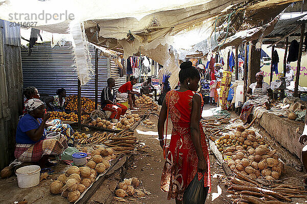 People selling roots and coconuts at town market  Mozambique