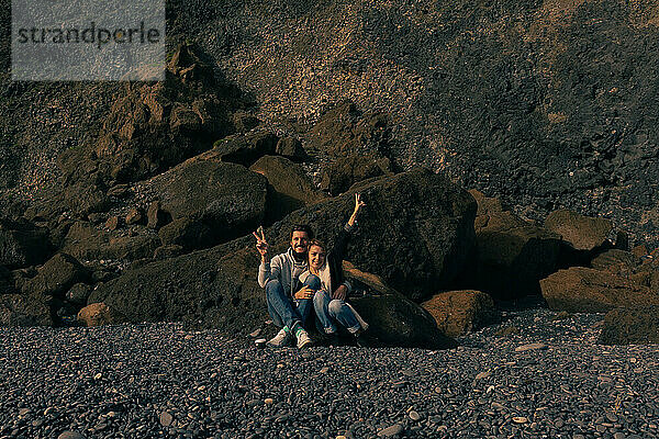 Couple amidst basalt columns of the Reynisfjara beach.