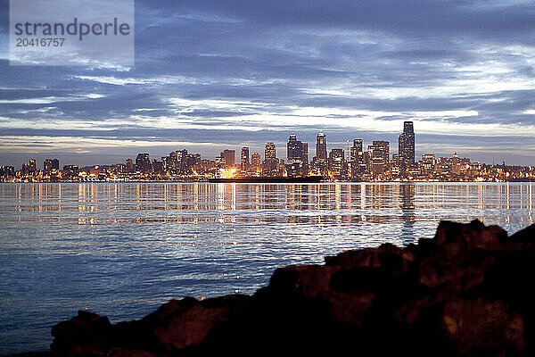 A city waterfront skyline at sunrise.