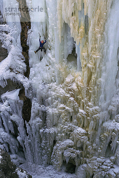 An ice climber ascends a frozen waterfall in Ouray  Colorado.