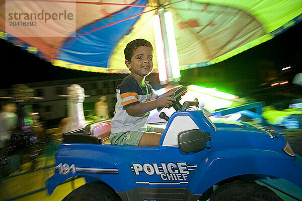 A young boy rides a merry-go-round on the Puerto Ayora waterfront in the Galapagos.