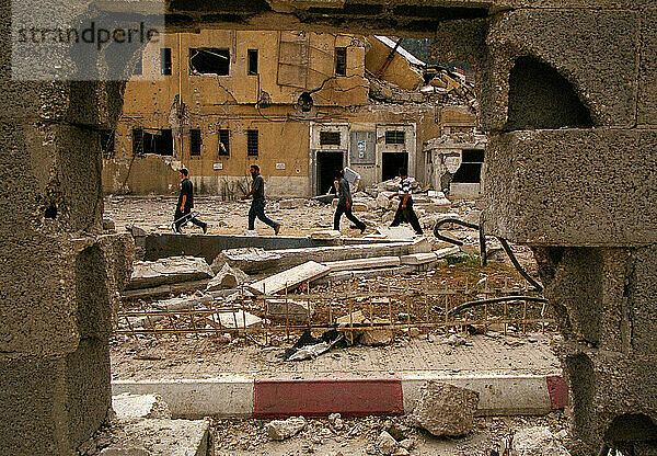 Men walk by Nablus Muquata