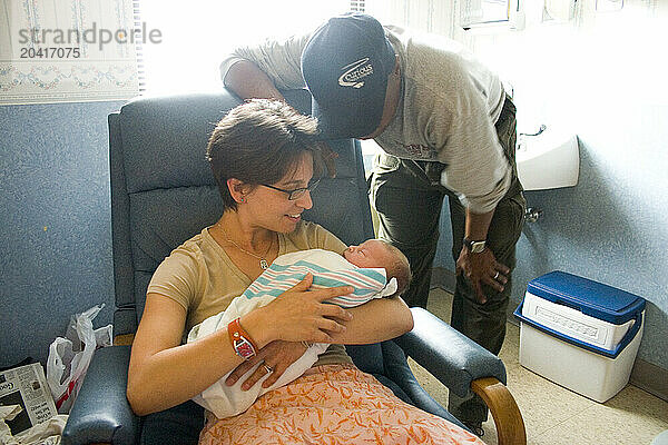 A young couple admires a new baby