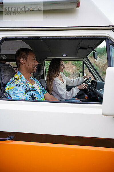 Young diverse couple travelling in van together in daytime