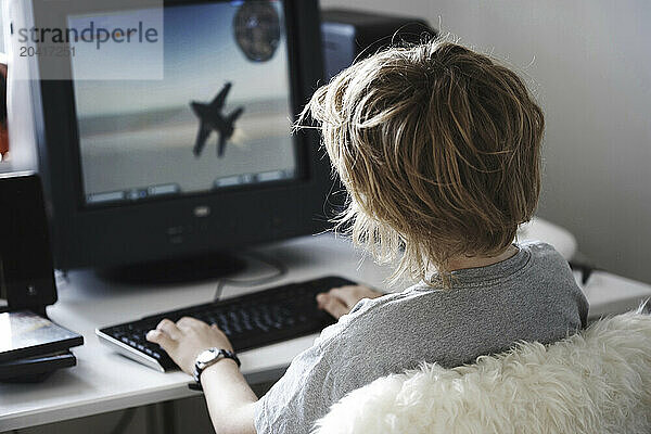 Young boy playing computer game.