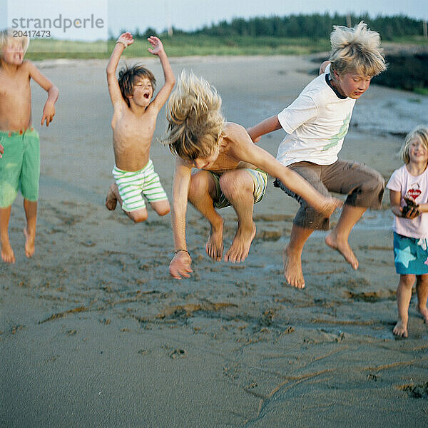 children jumping on beach