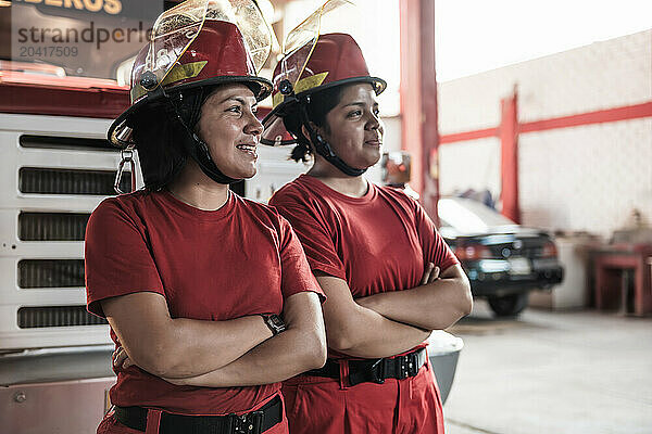 Portrait of smiling female firefighter standing at fire station