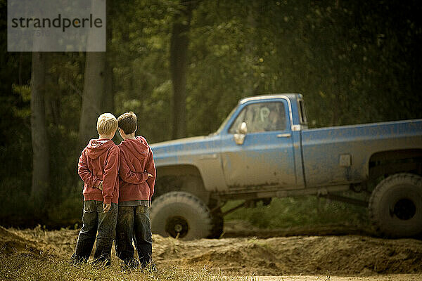 Two brothers look at an off road vehicle in Toronto  Ontario.