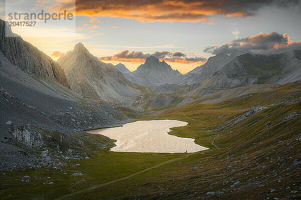 Vibrant Sunset over Rugged Ubaye Peaks Reflected in Lac de l'Orrenaye