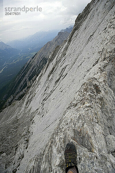 A lone shoe heads out on the knife-edge limestone ridge of Mt. Lady MacDonald under stormy skies in Alberta's Canadian Rockies on 8/1/2010