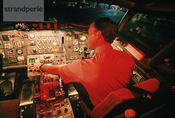 A Captain checks controls inside cockpit of a jet before departure  Maine  USA.