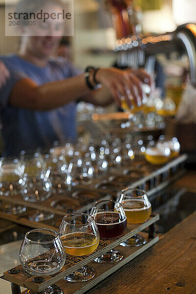 Bartender pours beers for tasting at Allagash Brewery