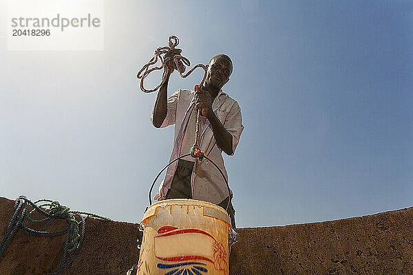 man fetching water from a well in the sahel region of the Senegal river  Senegal