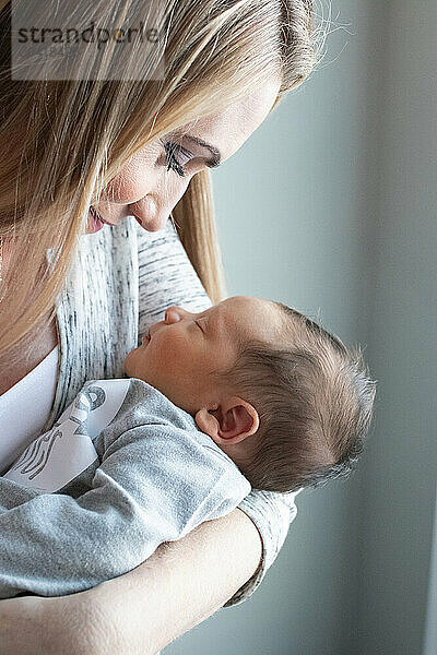 Mother holding sleeping newborn in tender embrace