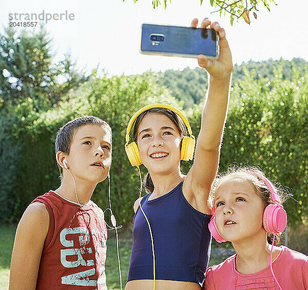 portrait of three boys in sportswear standing taking a selfie