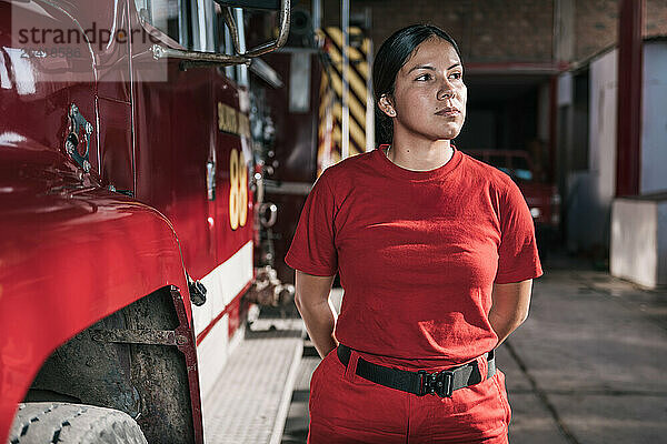 Portrait of female firefighter standing at fire station