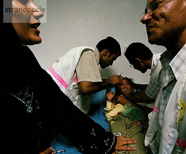 Nablus UPMRC Dr. Saber discusses local news with a mother who brought her son into the neighborhood clinic after he fell and recieved a gash in his head. UPRMC volunteer Mustafa Ma