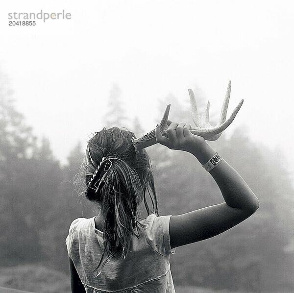 girl with one antler on foggy morning