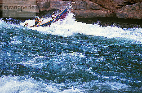 A whitewater dory punches through a wave in House Rock Rapid on the Colorado River in Grand Canyon National Park  Arizona.