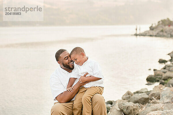 Father and son outside by the water laughing together