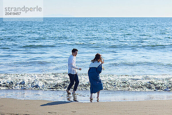 Japanese couple walking on the beach