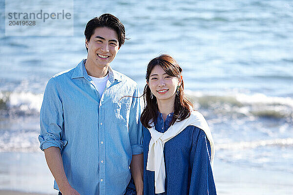 Japanese couple standing on the beach