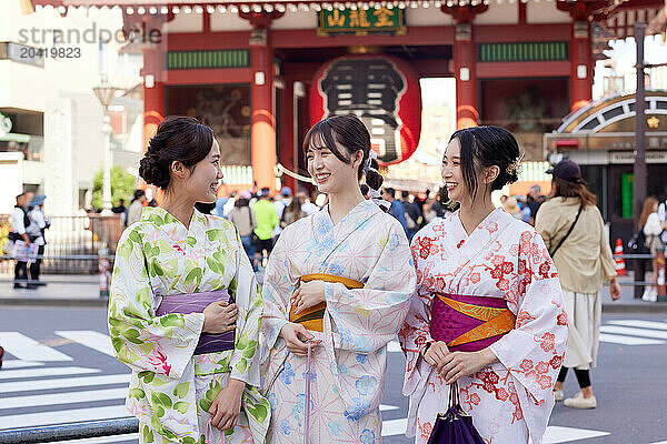 Japanese friends wearing yukata visiting traditional temple in Tokyo