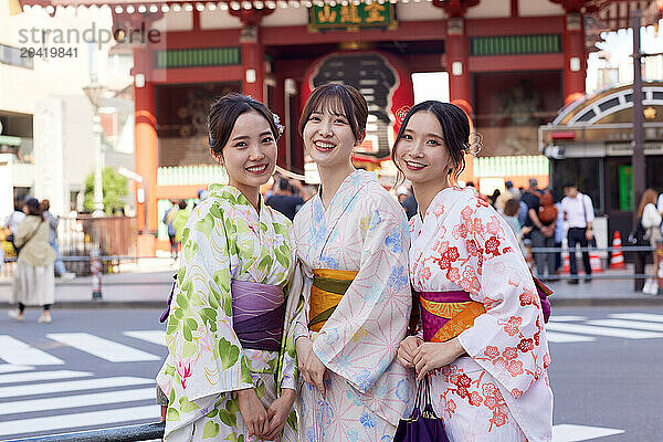 Japanese friends wearing yukata visiting traditional temple in Tokyo