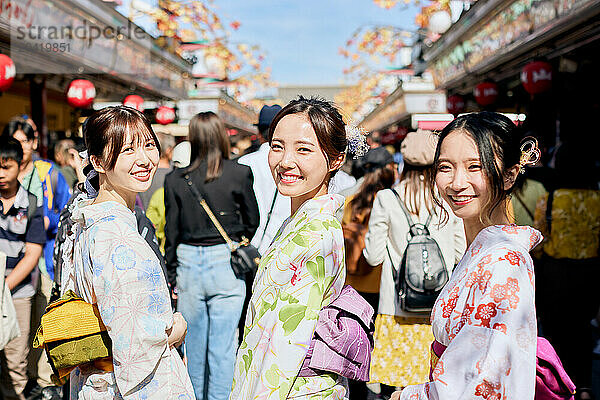 Japanese friends wearing yukata visiting traditional temple in Tokyo