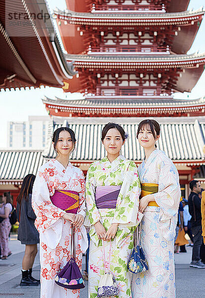 Japanese friends wearing yukata visiting traditional temple in Tokyo