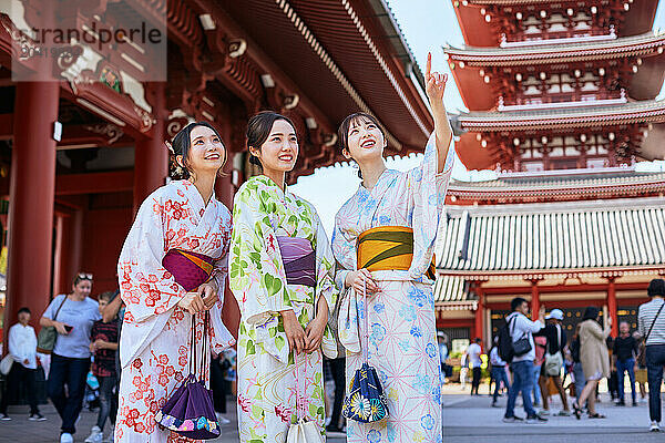 Japanese friends wearing yukata visiting traditional temple in Tokyo