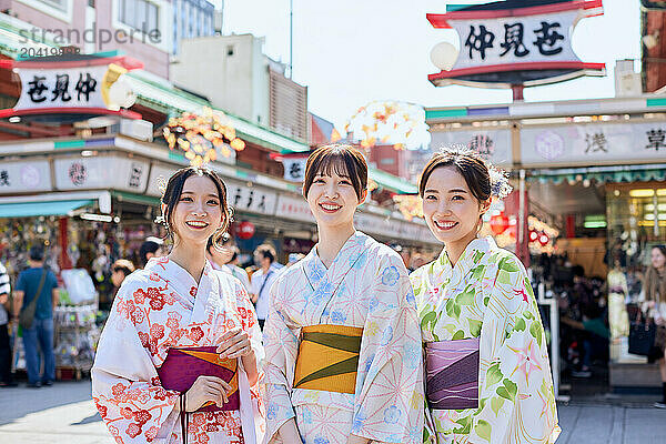 Japanese friends wearing yukata visiting traditional temple in Tokyo