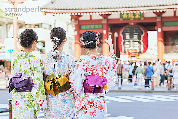 Japanese friends wearing yukata visiting traditional temple in Tokyo