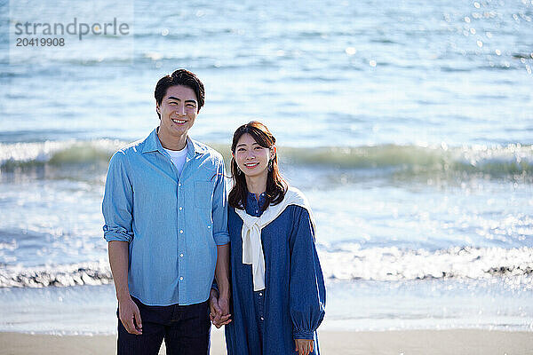 Japanese couple standing on the beach