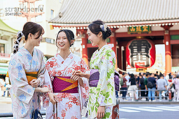 Japanese friends wearing yukata visiting traditional temple in Tokyo