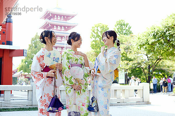 Japanese friends wearing yukata visiting traditional temple in Tokyo