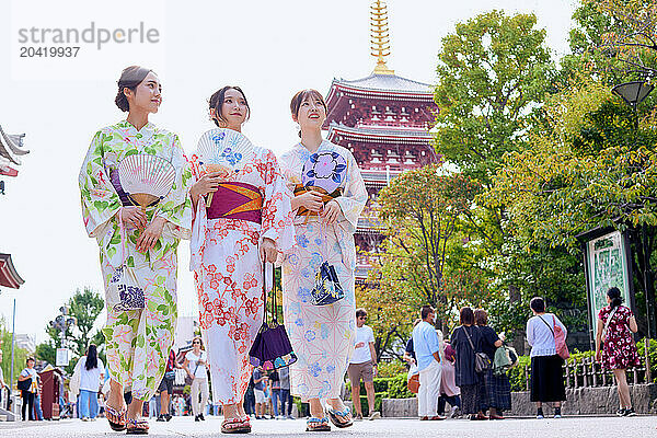 Japanese friends wearing yukata visiting traditional temple in Tokyo