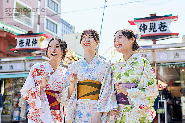 Japanese friends wearing yukata visiting traditional temple in Tokyo