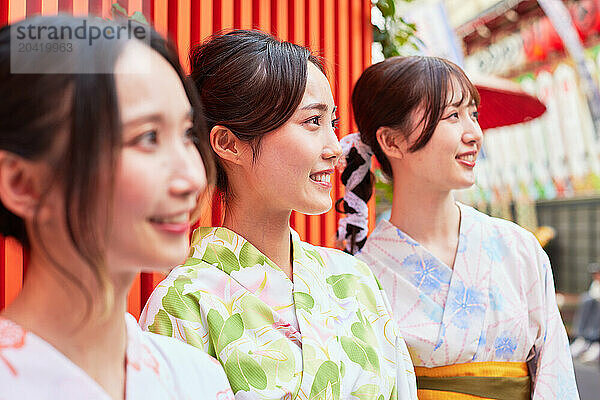 Japanese friends wearing yukata visiting traditional area in Tokyo