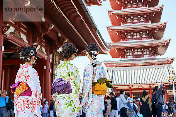 Japanese friends wearing yukata visiting traditional temple in Tokyo